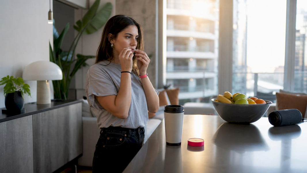 Woman placing caffeine pouch under lip