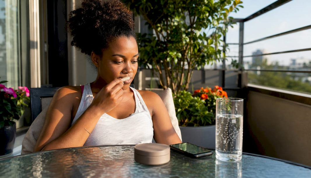 Woman using tobacco-free nicotine pouch indoors